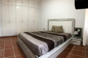 Vilassar de DaltALOJAMIENTO CON JARDIN 20KM BARCELONA的一间卧室配有一张大床和白色橱柜。