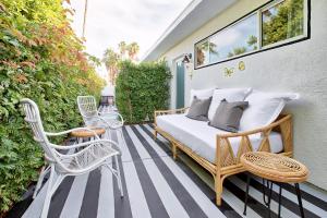 棕榈泉Dive Palm Springs的一间卧室,在庭院里配有一张床和椅子