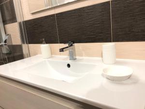 萨沃纳Elle's House的浴室设有白色水槽和镜子