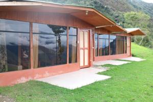 SalcantayLlactapata Lodge overlooking Machu Picchu - camping - restaurant的草山上的玻璃门房子