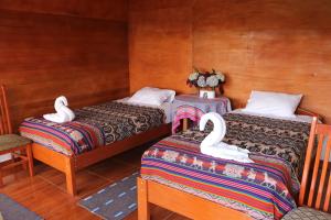 SalcantayLlactapata Lodge overlooking Machu Picchu - camping - restaurant的配有2张床的宿舍间,配有天鹅