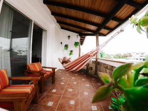 阿约拉港Hotel Cucuve的客房的阳台配有吊床和椅子。