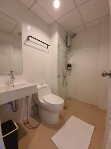 乌隆他尼T-NEE Hotel@Udon的浴室配有卫生间、盥洗盆和淋浴。