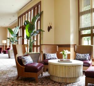 波特兰瑞尔普雷斯金普敦酒店的大堂设有咖啡桌、椅子和桌子。