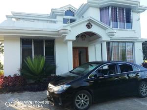 苏瓦Suva Hideaway Villa的一辆停在白色房子前面的黑色汽车