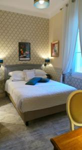昂蒂布波斯蒂莱恩酒店的一间卧室设有一张大床和一个窗户。