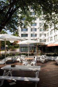华盛顿Glover Park Hotel Georgetown的庭院配有白色的桌椅和遮阳伞。