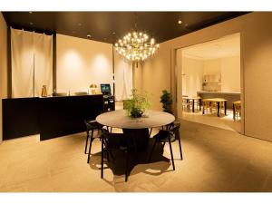 福冈9 HOTEL Hakata的用餐室以及带桌子和吊灯的厨房