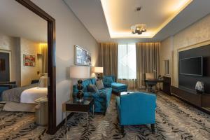 利雅德利雅得皇冠假日酒店 - RDC酒店与会议中心的酒店客房配有床、沙发和电视。