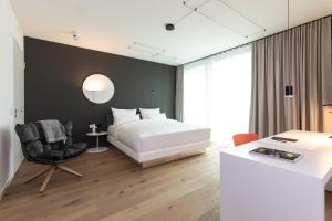 柏林KPM Hotel & Residences的一间卧室配有一张床、一张桌子和一把椅子