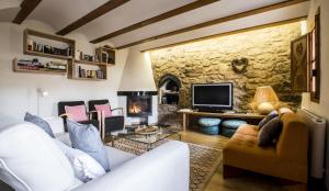 OlbaLa Casa de Los Moyas的客厅配有白色沙发和石墙