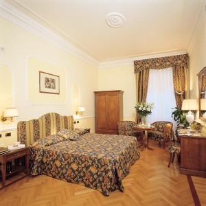 罗马Hotel Cellini的卧室配有一张床和一张桌子及椅子