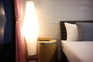 高兰Marina hut guest house的坐在房间床边的灯