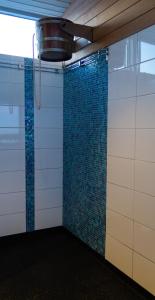 斯图吕曼Hotell Toppen的墙上设有蓝色瓷砖淋浴室