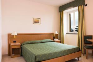 阿伦扎诺里维埃拉酒店的一间卧室设有一张绿色的床和一个窗户。