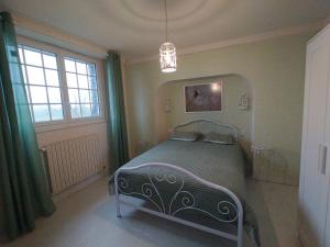 Saint-SauveurLes Chambres de KERCHELGEN的一间卧室配有一张床和一个吊灯