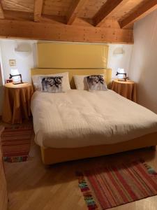 卡瓦莱塞Chalet montagna e relax Volpe Rossa的一间卧室配有一张大床和两张桌子