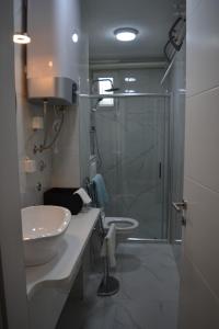 萨拉热窝Apartman Dejna的带淋浴、盥洗盆和淋浴的浴室