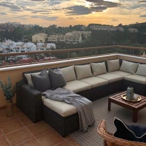 贝纳尔马德纳Luxurious duplex penthouse with golf and sea views的市景阳台的沙发