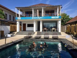 吉利特拉旺安梦幻潜水者度假酒店的一群人在房子前的游泳池里