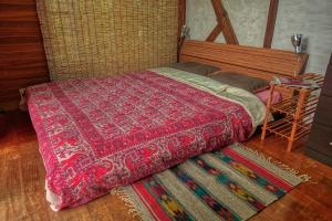 石垣岛435的一间卧室配有一张带红色棉被的床和一张桌子