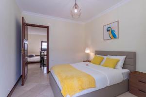 埃斯托利尔Heart of Ocean Dulpex Estoril的一间卧室配有一张带黄色枕头的大床