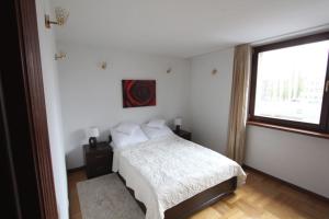 华沙Apartment Nowiniarska near the Old Town的白色的卧室设有床和窗户