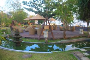 艾湄湾雅艾姆德Spa度假村的庭院里的池塘,配有桌椅