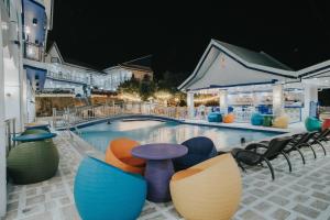 SantiagoSantiago Cove Hotel and Restaurant的一座带椅子和桌子的大型游泳池位于游泳池前