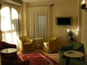 因普鲁内塔别墅安博罗西娜的客厅配有桌椅和电视