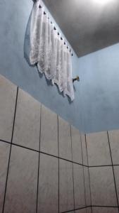 瓜鲁柳斯Quarto familiar, aeroporto Guarulhos的浴室设有挂在墙上的白色窗帘