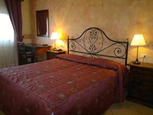 因普鲁内塔别墅安博罗西娜的一间卧室配有一张大床和红色的床罩