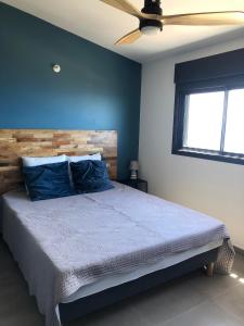 圣勒OCEAN SUNSET的一间卧室配有一张蓝色墙壁的床和吊扇