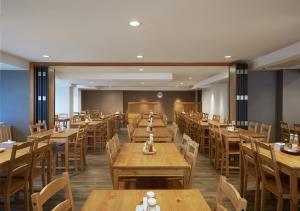 曼谷Prom Ratchada Hotel - SHA Plus的用餐室配有木桌和椅子