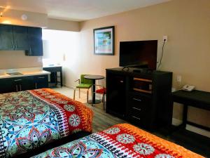 克利尔沃特Tropical Inn & Suites, downtown clearwater的酒店客房设有两张床和一台平面电视。