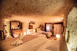 格雷梅Kamelya Cave Hostel的一间洞穴内带两张床的卧室
