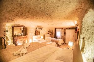格雷梅Kamelya Cave Hostel的石洞内一间卧室,配有两张床