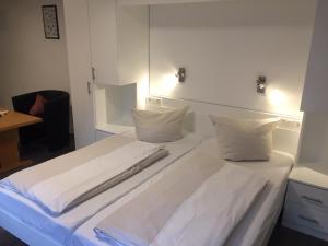 圣马丁拉贝木屋酒店的一张白色大床,配有白色床单和枕头