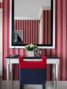 伦敦菲尔姆戴尔酒店集团多塞特广场酒店的红色和白色的客房配有带红色椅子的书桌