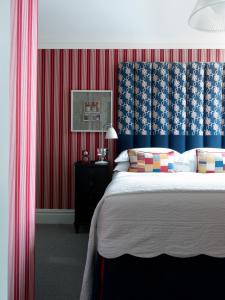伦敦菲尔姆戴尔酒店集团多塞特广场酒店的一间卧室配有一张带红色和蓝色壁纸的大床
