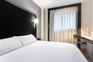 赫塔费B&B HOTEL Madrid Getafe的卧室设有一张白色大床和一扇窗户。