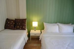 象岛象岛班普度假酒店的一张桌子上灯的房间里两张床铺