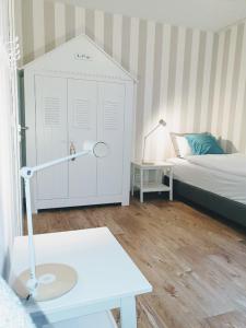 岑平Ferienhaus Inselliebe mit Sauna的一间小卧室,配有床和白色橱柜