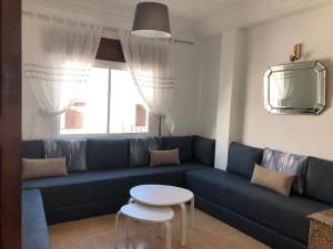 米迪克Jolie appartement vue mer的客厅配有蓝色的沙发和桌子