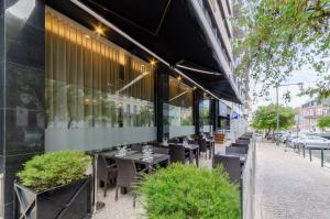 里斯本特里姆阿拉马科斯酒店的大楼前设有桌椅的餐厅