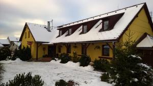霍尼普拉纳Penzion Lipno Jantar的上面有雪的黄色房子