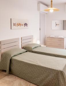 梅斯特Appartamento Le Barche 2的卧室设有2张床和白色的墙壁。