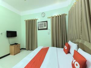 苏尔Super OYO 108 Marsa Al Masafar Hotel Apartment的一间卧室配有一张带红色枕头的床和一台电视。