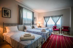 乌姆盖斯Beit Al Baraka的一间卧室配有两张床,铺有红地毯