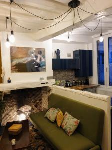 鲁昂Maison hypercentre Rouen tout confort的客厅在壁炉前设有绿色沙发